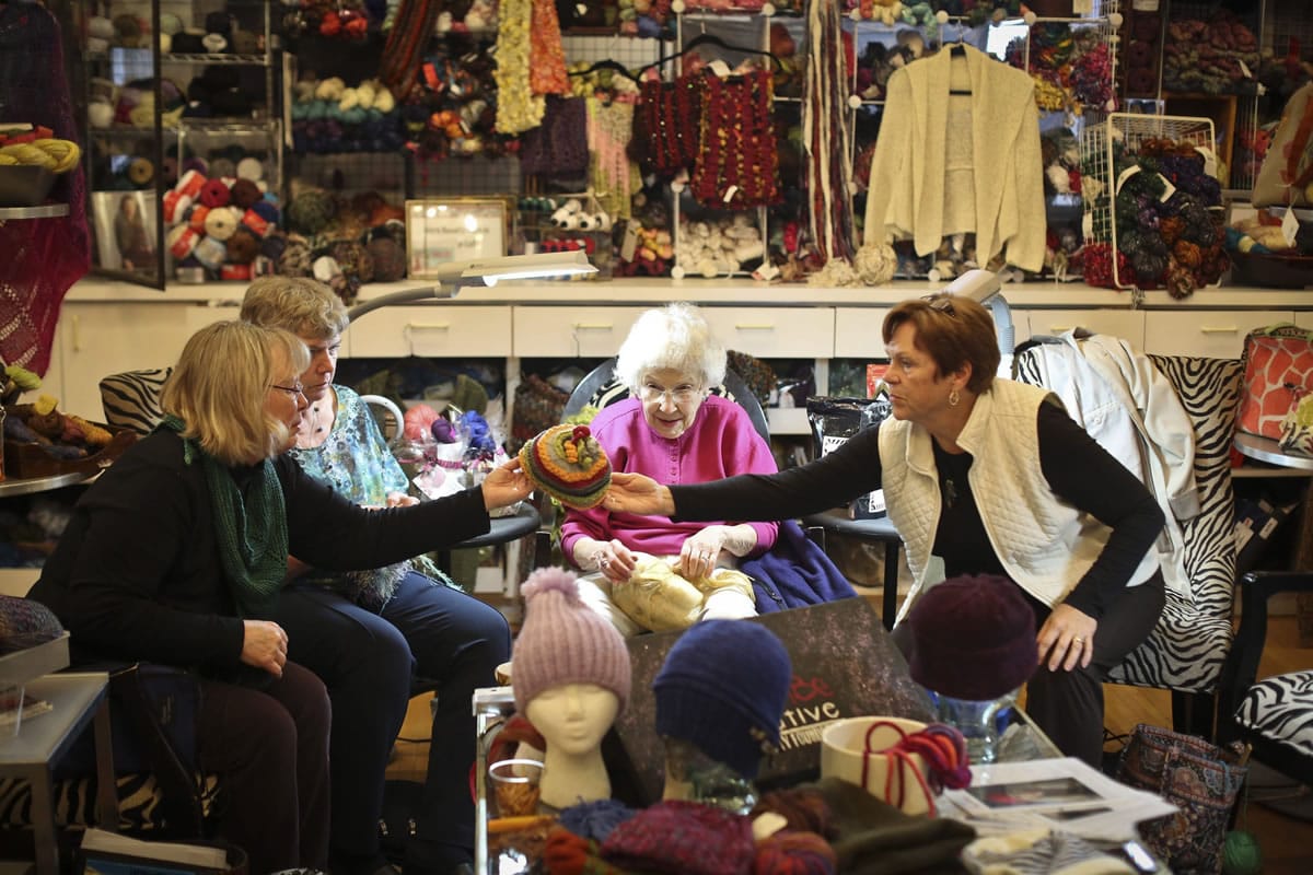 Maggie Clements, from left, Judith Grittner, Elaine Howe and Mary DeBruin admire a hat as they knit for the charity group Hats for the Homeless in Minneapolis.