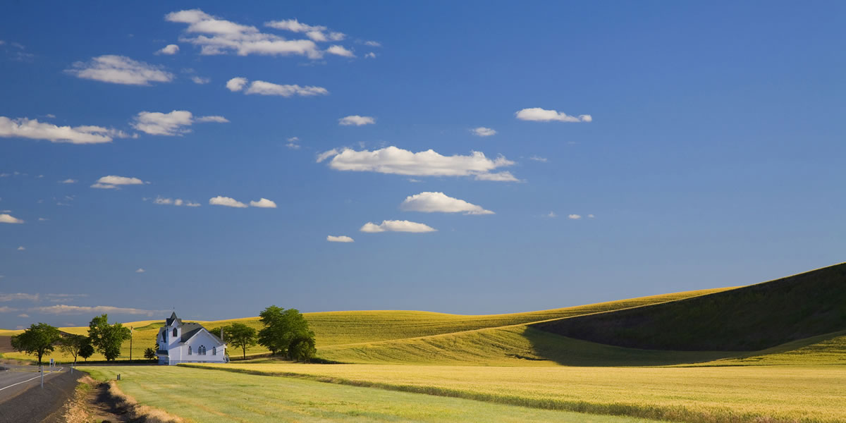 A church in the Palouse area of Eastern Washington sits among the endless wheat fields on a summer day.