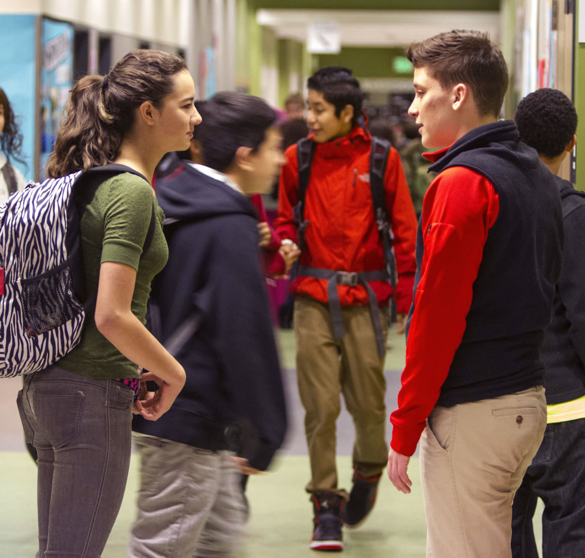 City Year corps member Becka Gross, right, and student Taylor Trimming chat in the hallway between classes at Denny Middle School in Seattle.