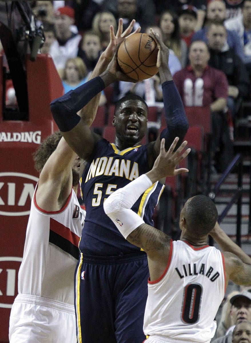 Indiana Pacers center Roy Hibbert, middle, is double teamed by the Portland Trail Blazers' Damian Lillard, right, and Robin Lopez.