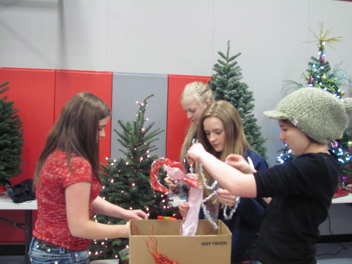 Canyon Creek Middle School ASB representatives (clockwise, from left) Natalie Garner, Bridgette McCarthy, Danielle Smyth and Jeannine Jones decorate a tree in school colors of silver and red.