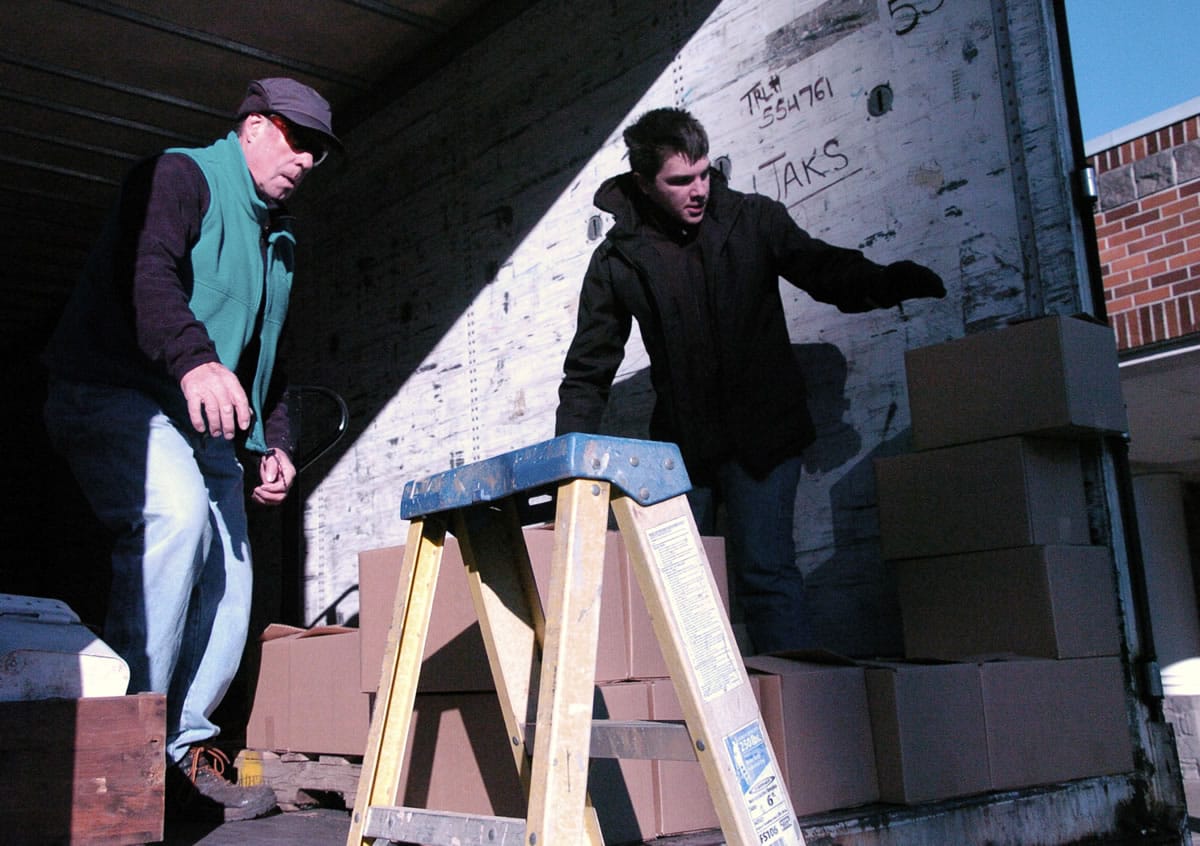 Walk &amp; Knock volunteers Toby Elliot, left, and Thomas Gilsrud load up boxes of donated food Dec.