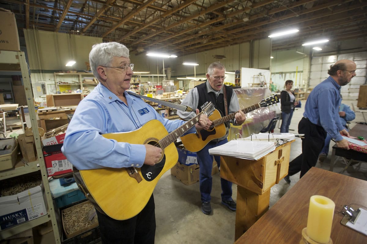 The Rev. Duane Sich, left, founder and longtime leader of homeless ministry Friends of the Carpenter, leads a musical prayer service on his 12-string guitar.