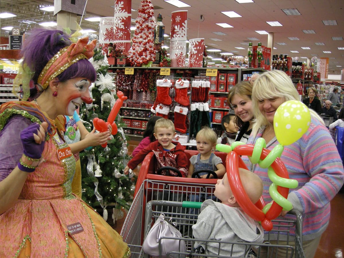 At the newly remodeled Fisher's Landing Fred Meyer, Cha Cha the Clown, left, creates a balloon hat for young Lily Bostrom, 9 months, to show to her family, from left, brother Exander, 4, sister Chloe, 2, mom Angie Bostrom and grandmother Cheryl Bostrom, all of Vancouver.