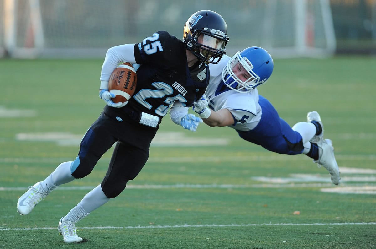Hockinson's Matt Henry (25) fights to elude the grasp of Sedro-Woolley's Spencer Hoover.
