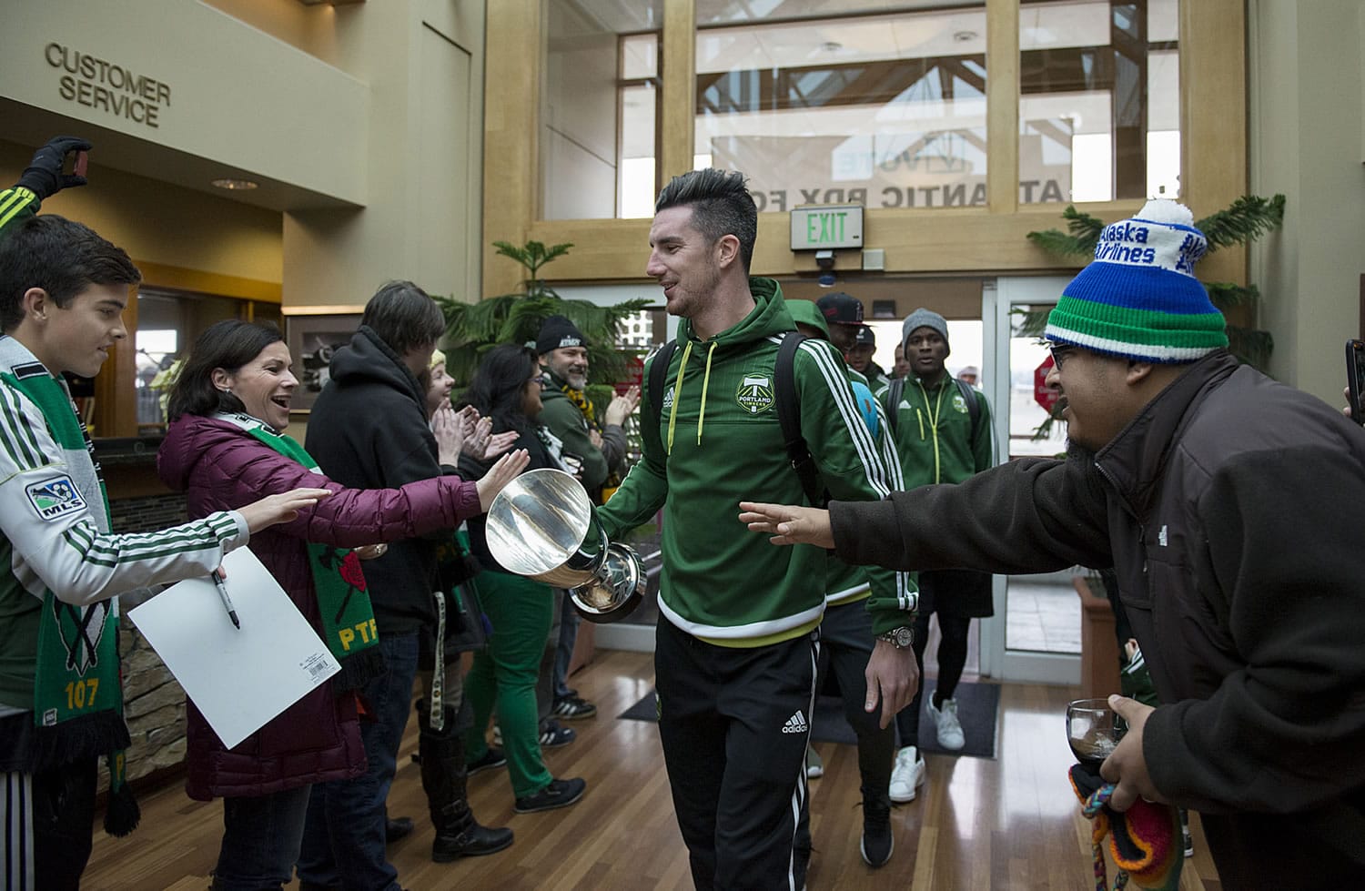 Timbers&#039; team captain Liam Ridgewell, center, greets a crowd of fans after arriving at the Business Aviation Terminal in Portland with teammates Monday morning, Nov. 30, 2015. The team was celebrating after winning the Major League Soccer Western Conference Championship.