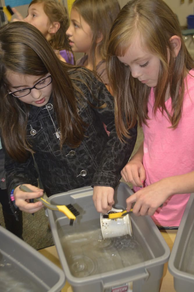 Washougal: Cape Horn-Skye Elementary School third-graders Megan West and Kylie Bowen wash a nearly 100-year-old cup in a recent lesson on archaeology.
