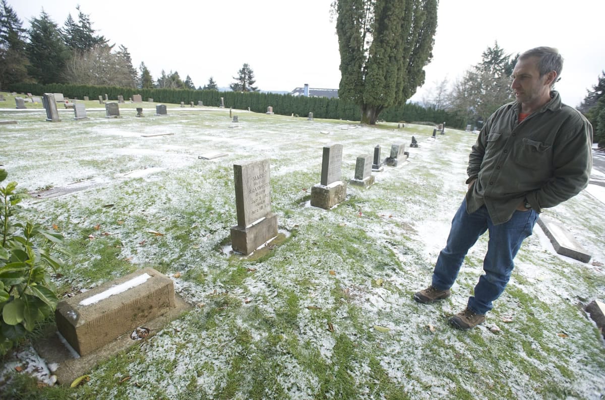 Ed Senchyna, senior grounds maintenance worker at Camas Cemetery, stands by the grave of Alexander Stuber.