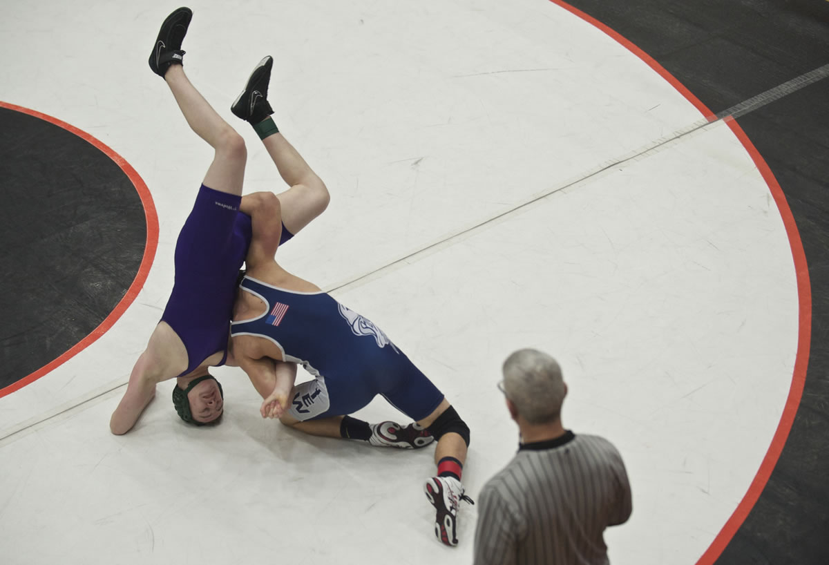 Skyview's Cameron Hutchison, right, turns Heritage High's Andrew McAllister on his head before pinning him during the 4A district wrestling championships at Battle Ground High School on Tuesday February 11, 2014.