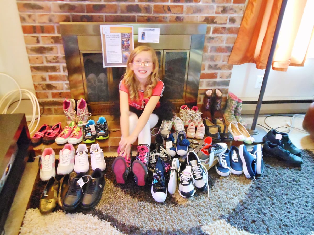 Following her 8th birthday party in November, Teagan gathers her gifts: shoes donated by family and friends that she and her mother, Ashley Carper, plan to give to those in need.