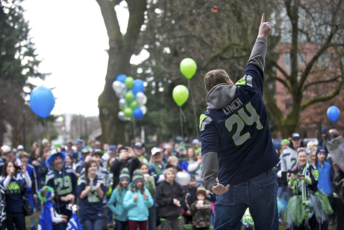 Peter Van Nortwick shows off his touchdown dance as he and other fans gather to show their support of the Seattle Seahawks Saturday morning at Esther Short Park.