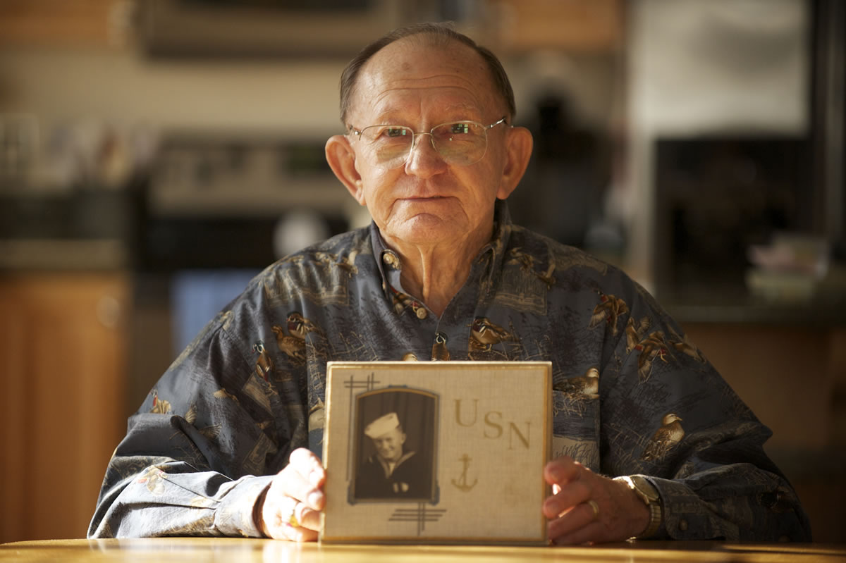 Navy veteran Ed Maresh shows a photo of himself as a 16-year-old sailor in 1943.