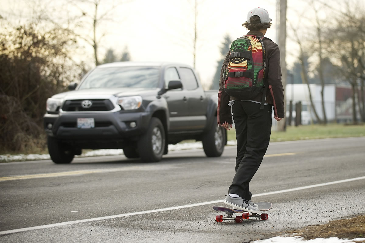 A skateboarder travels along Northeast 18th Street near Evergreen High School on Tuesday.