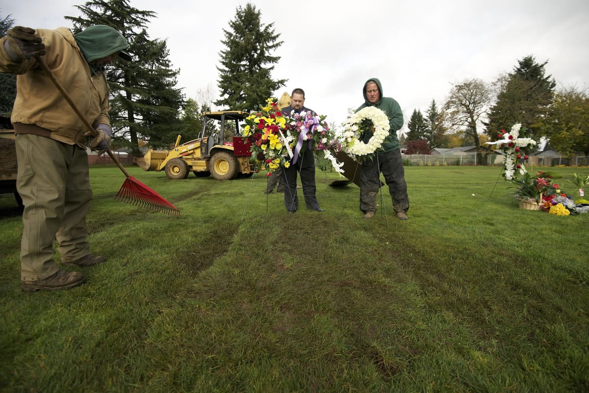 Grounds crew employee Terry Nichols, from left, Funeral Director Scott Bowen and grounds foreman Greg Melum arrange a grave site Nov. 7 at the Garden of Hope portion of Evergreen Memorial Gardens in Vancouver.