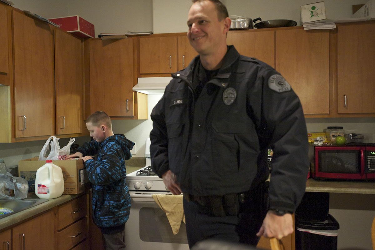 Colt Taub, 11, looks inside a box of food that was delivered by Vancouver Police Cmdr.