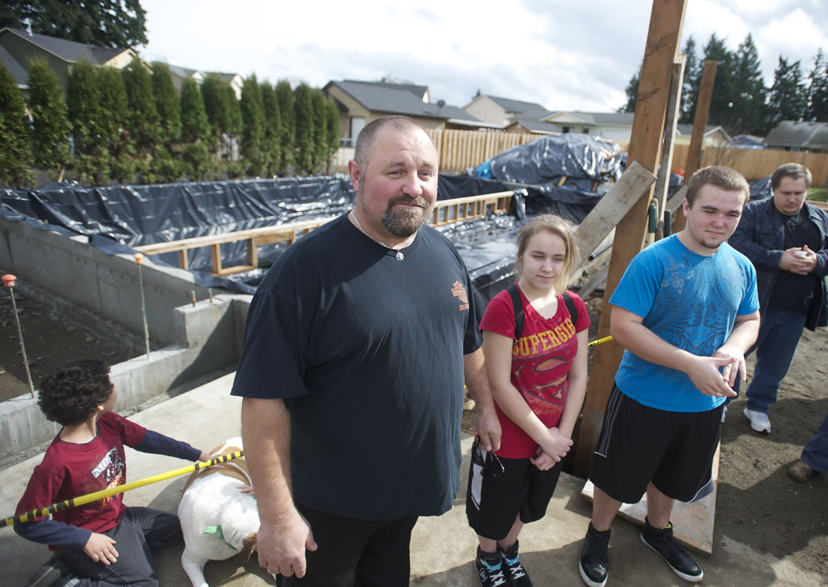 Doug West, 45, and his two children Cheyenne, 15, and Kody, 17, attend a ground-breaking on Sunday for their new Habitat for Humanity home in the Five Corners area.