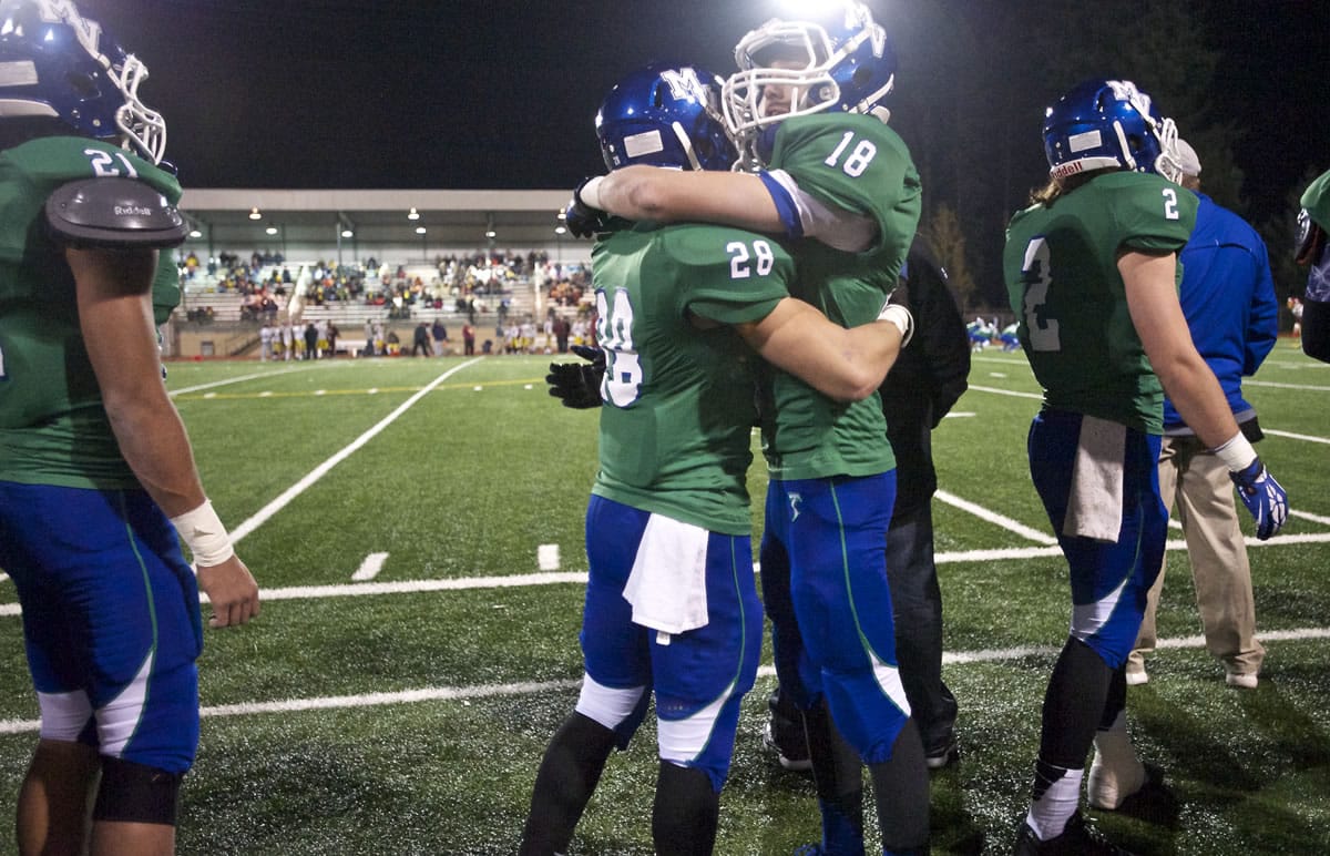 Mountain View's Avi Bharth, right, and Nick Niedermeyer hug late in the fourth quarter against O'Dea in the Class 3A state quarterfinal game at McKenzie Stadium on Friday November 22, 2013.