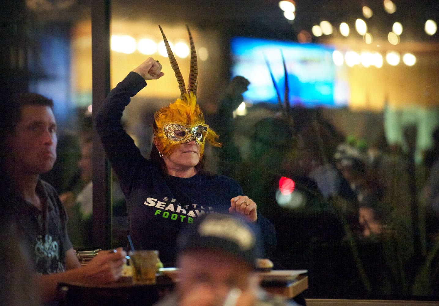 Seahawks stalwart Valerie Vance of Vancouver pumps her fist in the air during a rally at Main Event Sports Grill on Southeast 164th Avenue on Friday during an officially sponsored NFL team event. The rally was one of 12 around the state held in advance of today's playoff game vs. the New Orleans Saints.