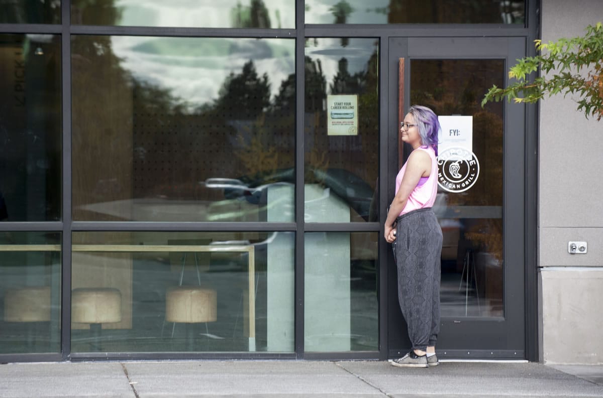 A woman approaches the front doors of the closed Chipotle Mexican Grill restaurant in Hazel Dell on Monday. Clark County Public Health officials closed the restaurant Thursday after linking several cases of E. coli to the restaurant.