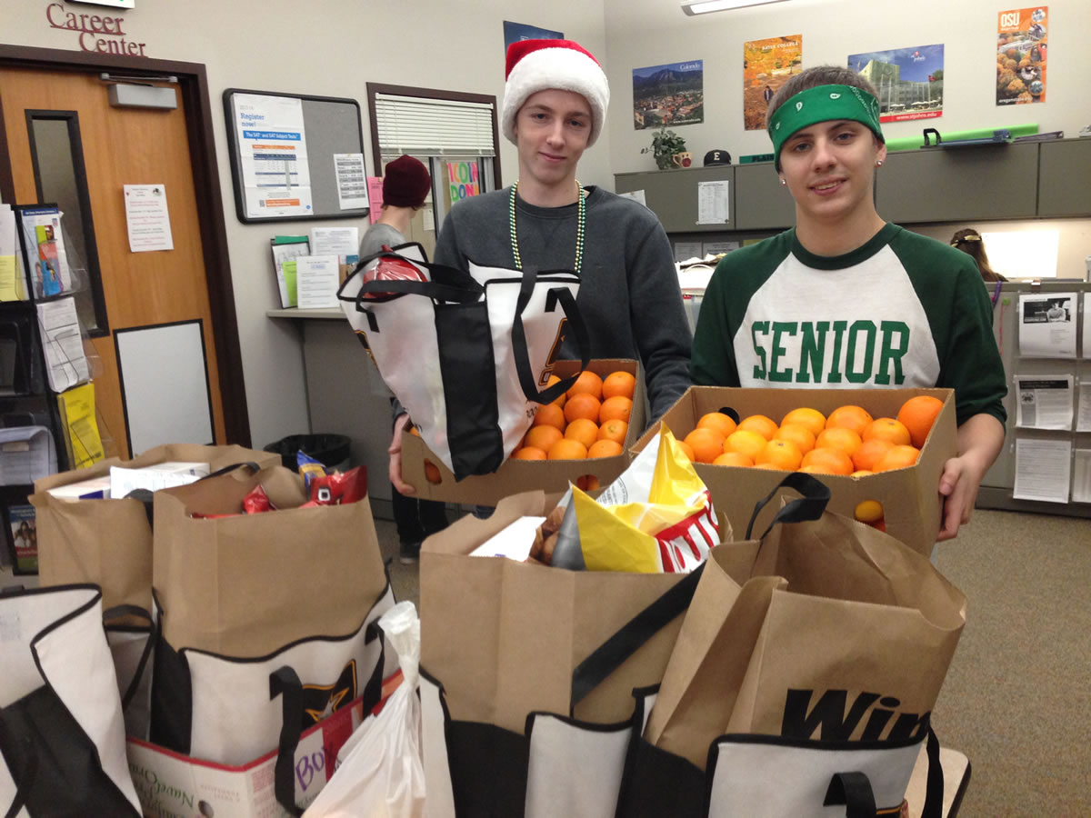 Evergreen High School: SkillsUSA students and iQ Credit Union campus branch co-managers Brian Shaffer, left, and Justin Morgan prepare bags of food that the campus gathered during a food drive for local families.