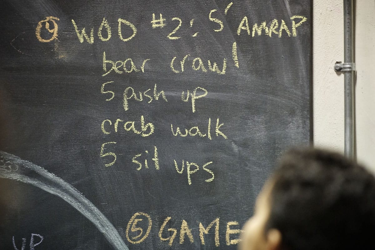 The CrossFit Kids workout for Wednesday evening is outlined on a chalkboard at Industrial CrossFit.