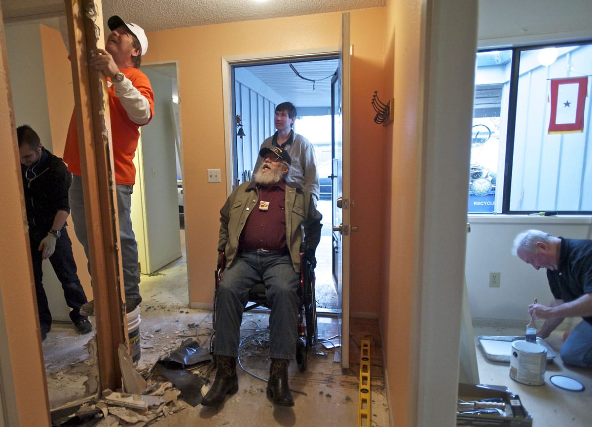 Rocco Tedesco checks on the progress of Home Depot volunteers as they start a project Wednesday to make his home wheelchair accessible.