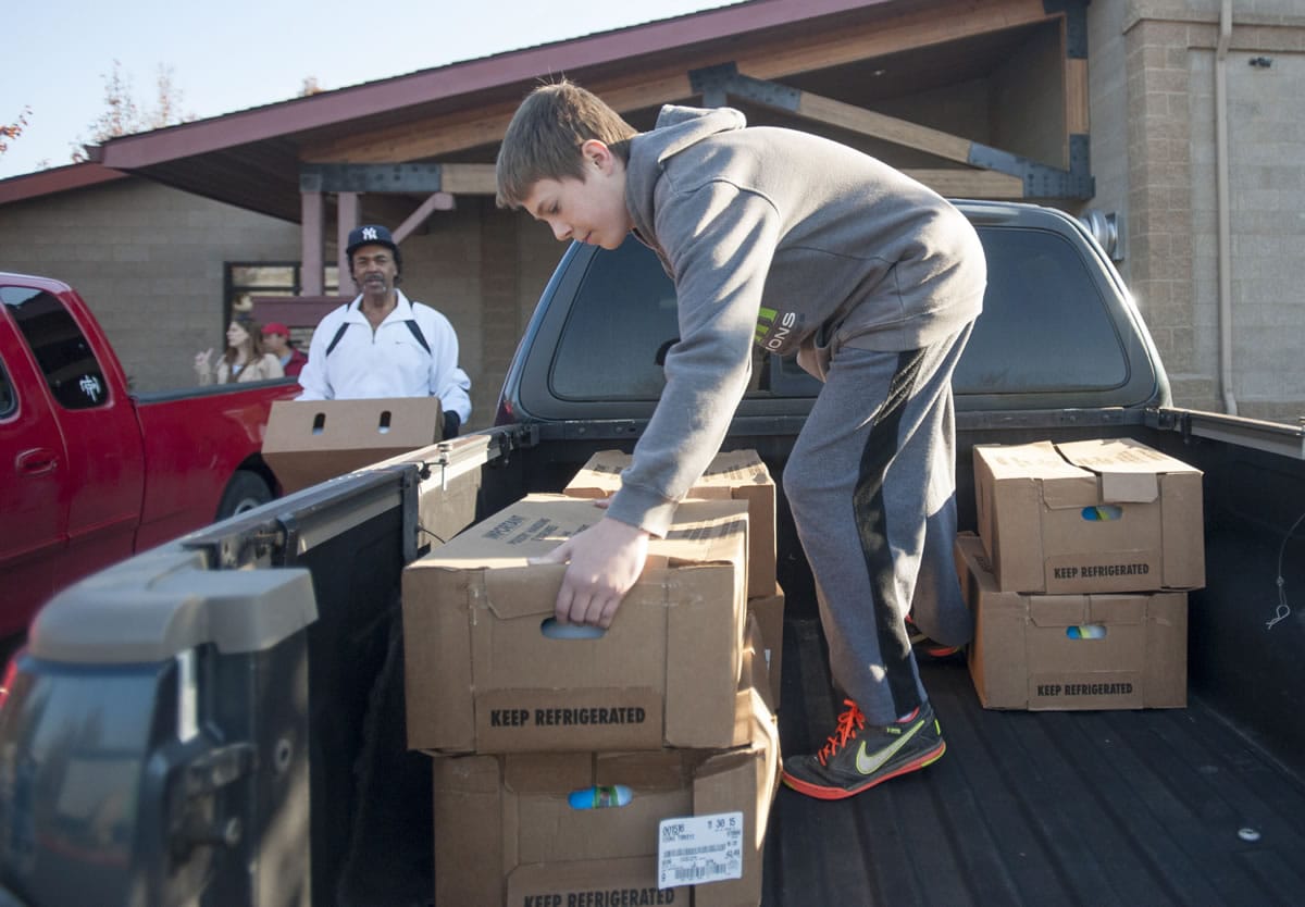Cody Turner 13, right and Kenneth Bass packs turkeys into a truck to be delivered to Silver Star Elementary School on Monday. Donations of turkeys and other food items will provide Thanksgiving dinner for  dozens of low-income families in Clark County. Students at Sunset Elementary and Hudson&#039;s Bay High schools also received donations.
