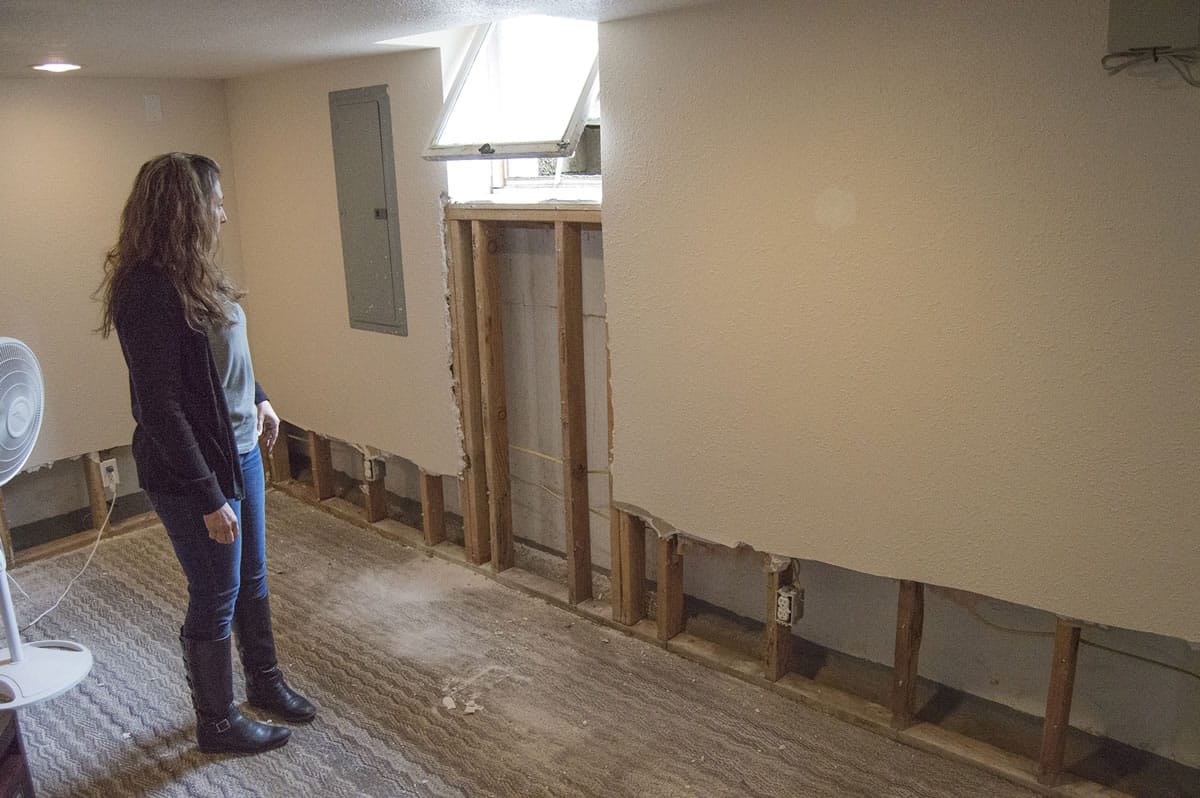 Debbie Hinesley surveys the damage water and mud from weekend storms wrought in the basement of her Greeley Street home in Camas.