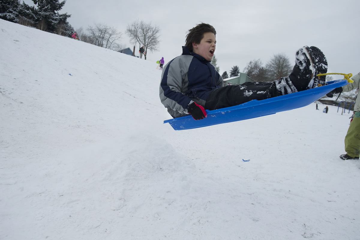 Matthew Bewick, 12, launches off a snow ramp while sledding at Franklin Elementary on Friday.