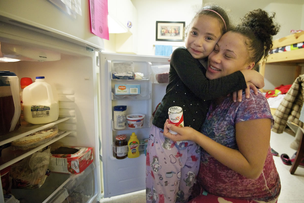 Taliah Litt, 6, left, hugs her mother Tiara Simms at their home at Open House Ministries.