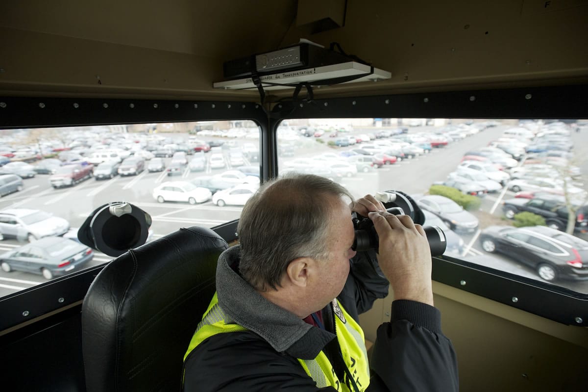Neighbors On Watch volunteer Bob Kennedy monitors the parking lot at Westfield Vancouver mall from the Vancouver Police Skywatch observation tower Friday.