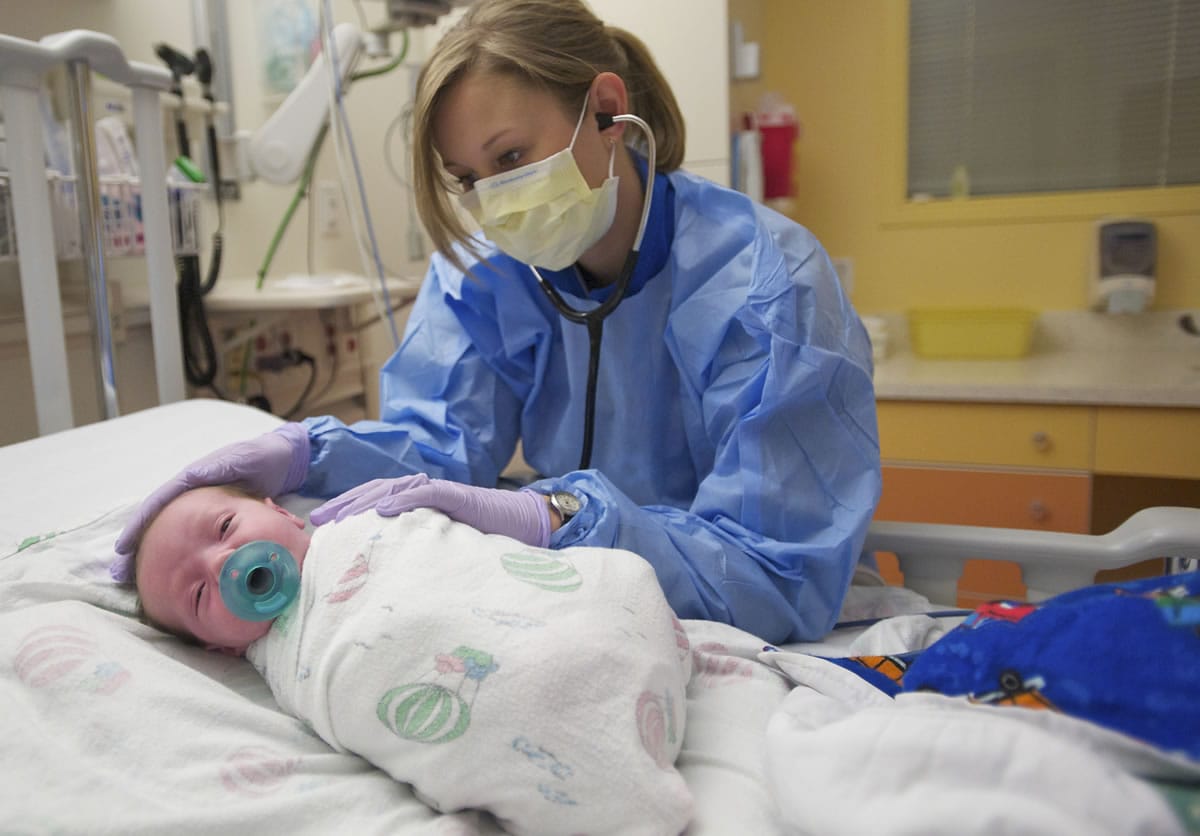 Kristina Kinnunen cares for a 3-week-old boy in the pediatric wing at Legacy Salmon Creek Medical Center on Nov. 14. Kinnunen started her career at Legacy as a housekeeper.