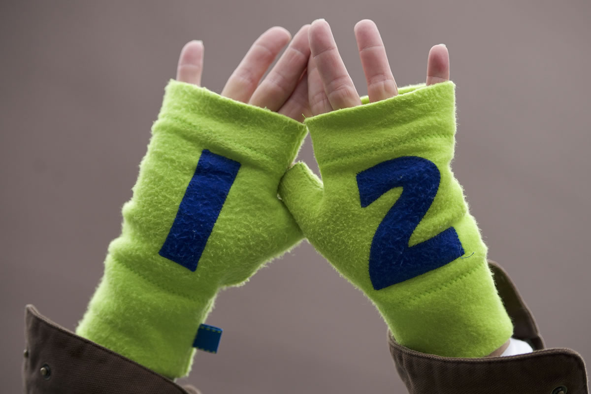 A Seattle Seahawks fan holds up 12th man gloves in support of the Seahawks before the start of the NFC Championship game at CenturyLink Field Sunday January 19, 2014 in Seattle, Washington.