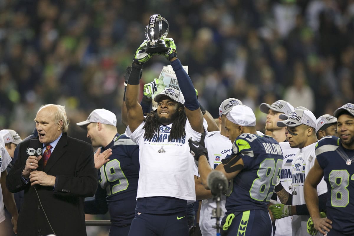 Richard Sherman hoists the George Halas Trophy with teammates after the NFC Championship game against the San Francisco 49ers at CenturyLink Field on Sunday.