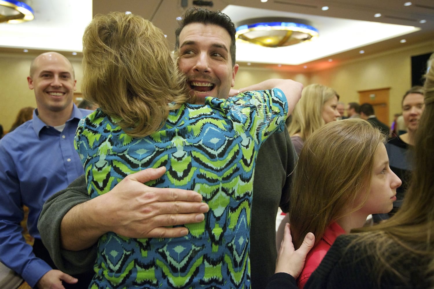 Ryan Bird is embraced by family and friends at the annual Amerian Red Cross Real Heroes Breakfast after being awarded a fire rescue hero award Friday.