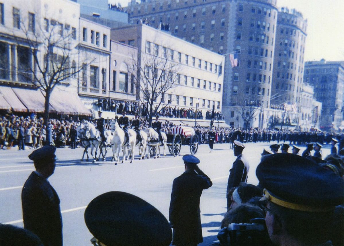 Holding a camera over his head, John Van Zytveld captured a photo of the caisson bearing the flag-draped coffin of John F. Kennedy on Nov. 25, 1963. Right: The caisson bearing John F. Kennedy's coffin rolls past mourners on the way to the cathedral on Nov.