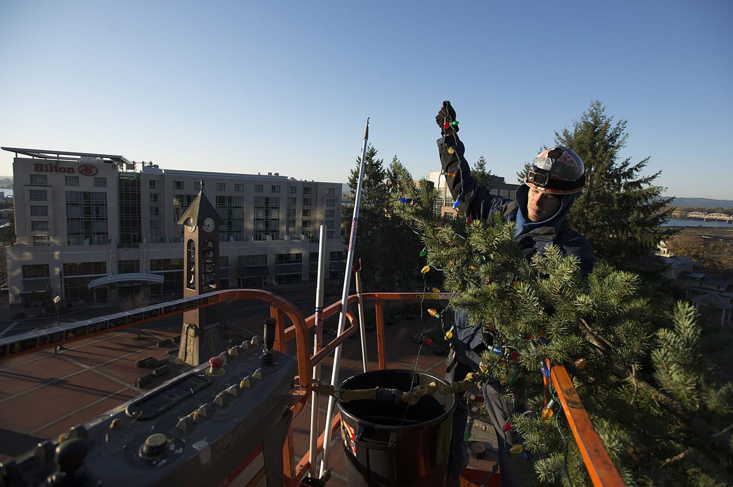 Cody Taplin of St. Mary&#039;s Services gets a bird&#039;s-eye view of downtown Vancouver while hanging Christmas tree lights Wednesday morning in Esther Short Park. The tree will be illuminated Friday.