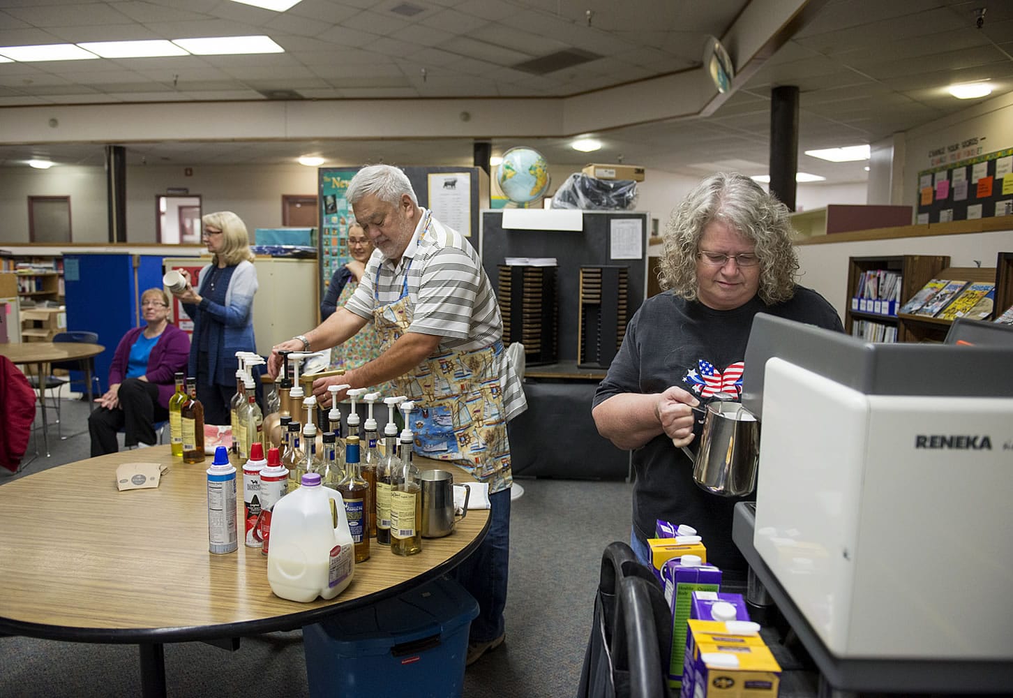 Northside Baptist Church members John Martin, center, and Cathy White, right, prepare coffee drinks for teachers and staff during a coffee cart event Nov. 10 at Gaiser Middle School. Volunteers from the church visit Gaiser and four elementary schools each month to treat teachers.