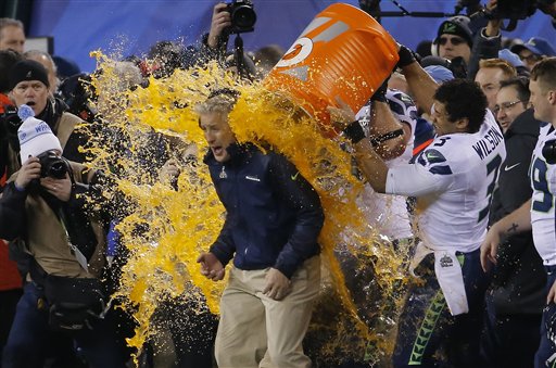 Seattle Seahawks quarterback Russell Wilson (3) dumps Gatorade on head coach Pete Carroll, celebrating the Seahawks' Super Bowl victory.