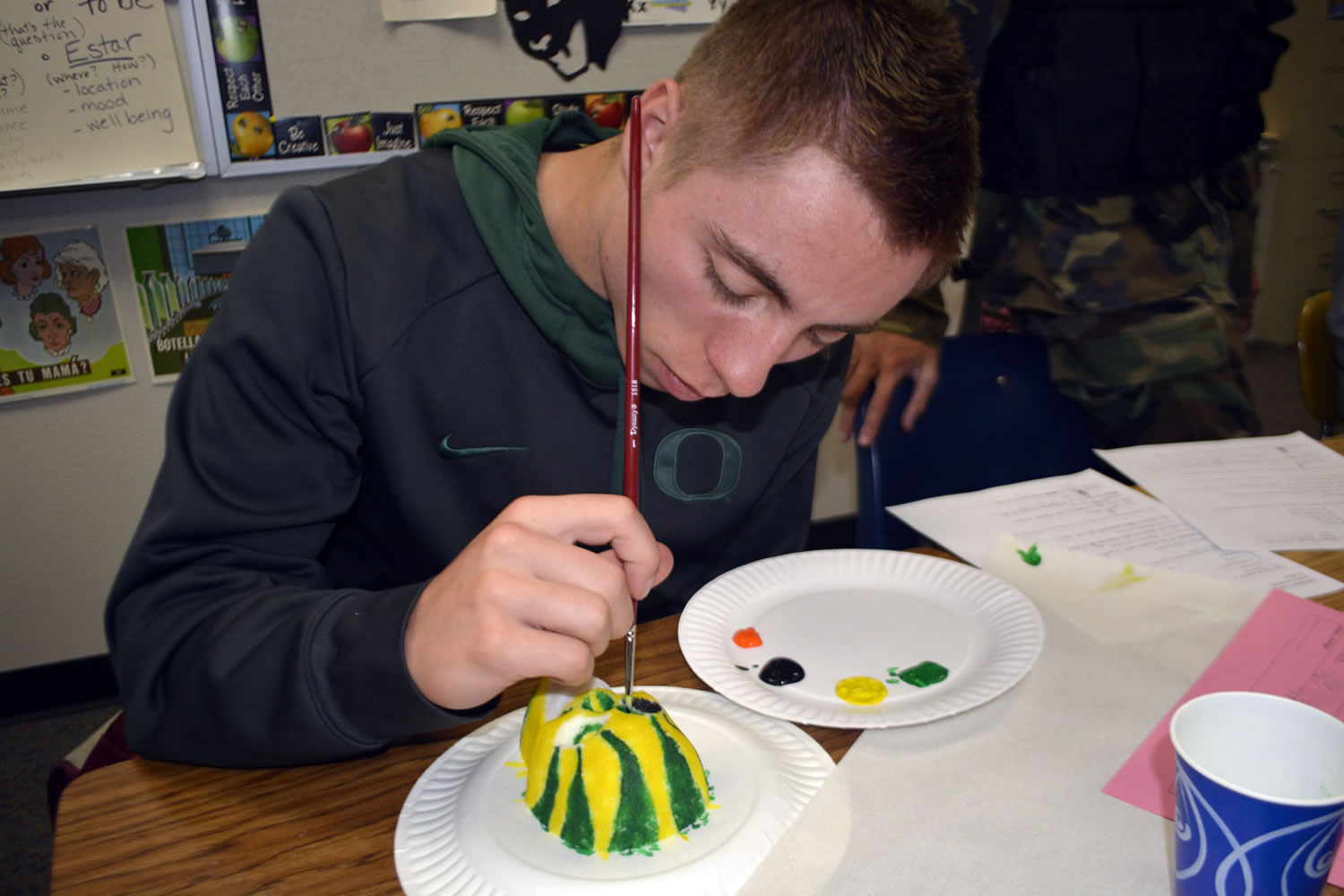 Washougal: Washougal High School Spanish language student Robert Jacobs paints a sugar skull in University of Oregon colors during a fall class lesson on Dia de los Muertos, the &quot;Day of the Dead.&quot;