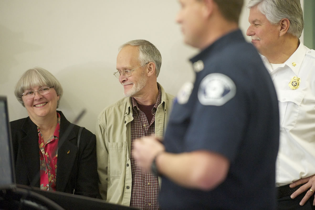 Candace Yarnell, left, smiles next to her husband, Herschel Yarnell, as Capt. Jason Mansfield of Fire District 3 talks during a PulsePoint media conference on Friday. Candace saved her husband's life earlier this year with help from a CRESA dispatcher when her husband went into cardiac arrest.