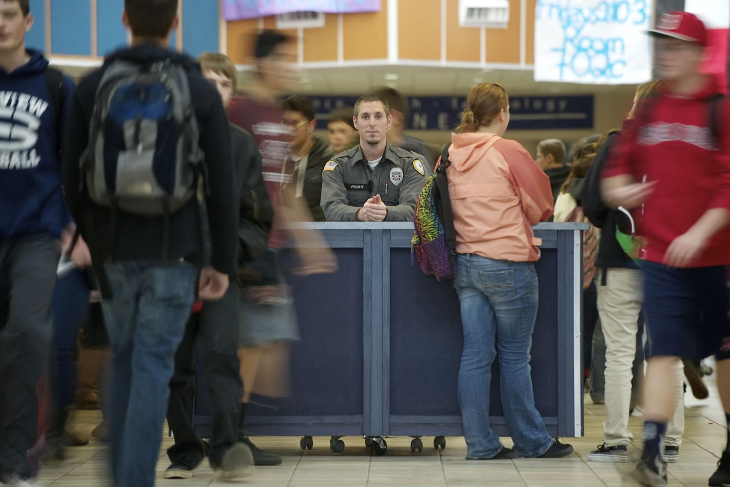 Vancouver School District Resource Officer Alex Wright keeps watch on students from a security kiosk just inside the main doors at Skyview High School.