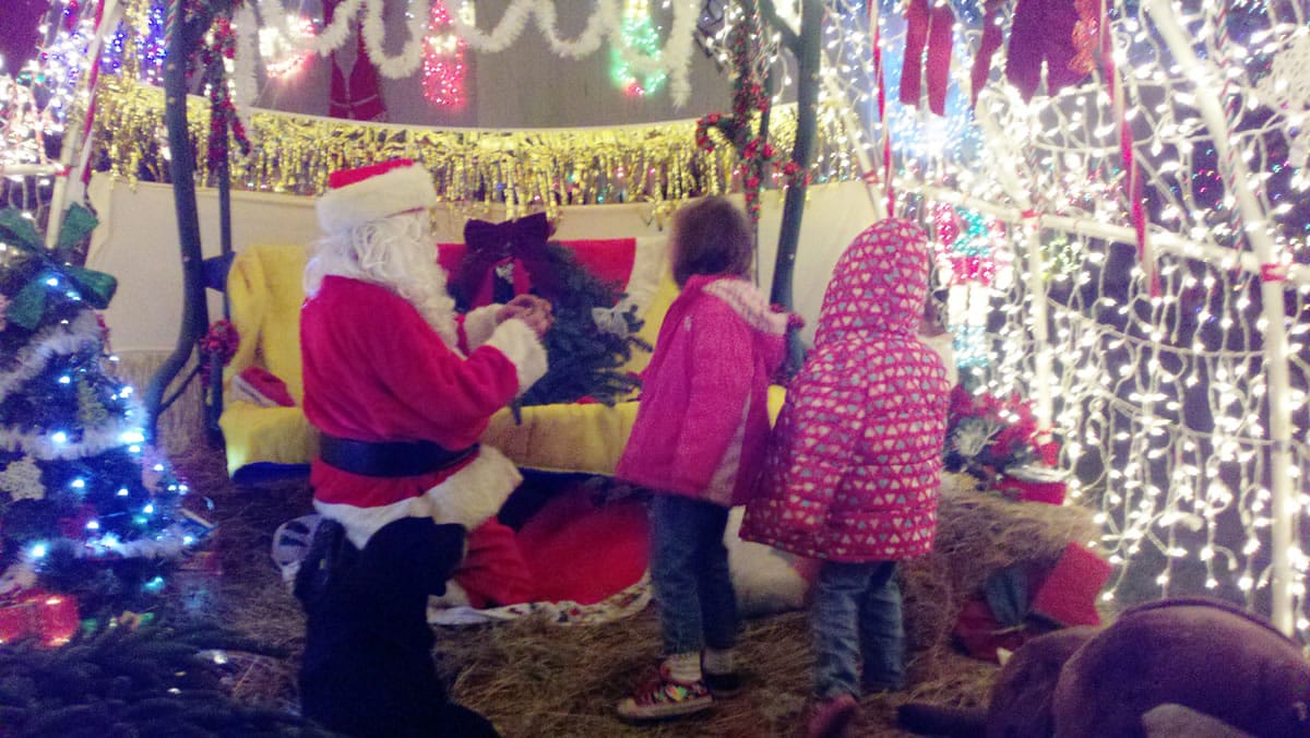 La Center: Bryan Miller, as Santa, helps children craft wreaths after they visited his home's Christmas display Dec.