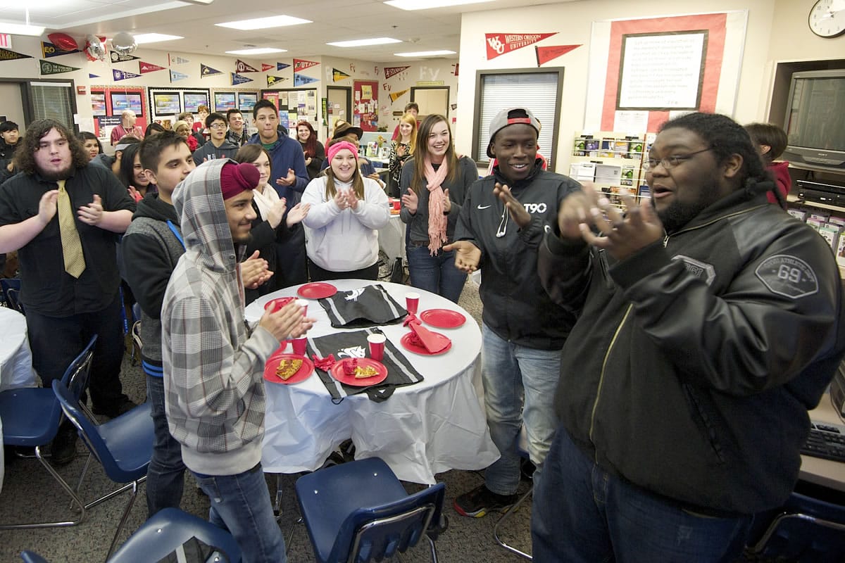 Jose Scott, 18, right, a senior at Fort Vancouver High School, learns to sing the Washington State University fight song with other seniors.