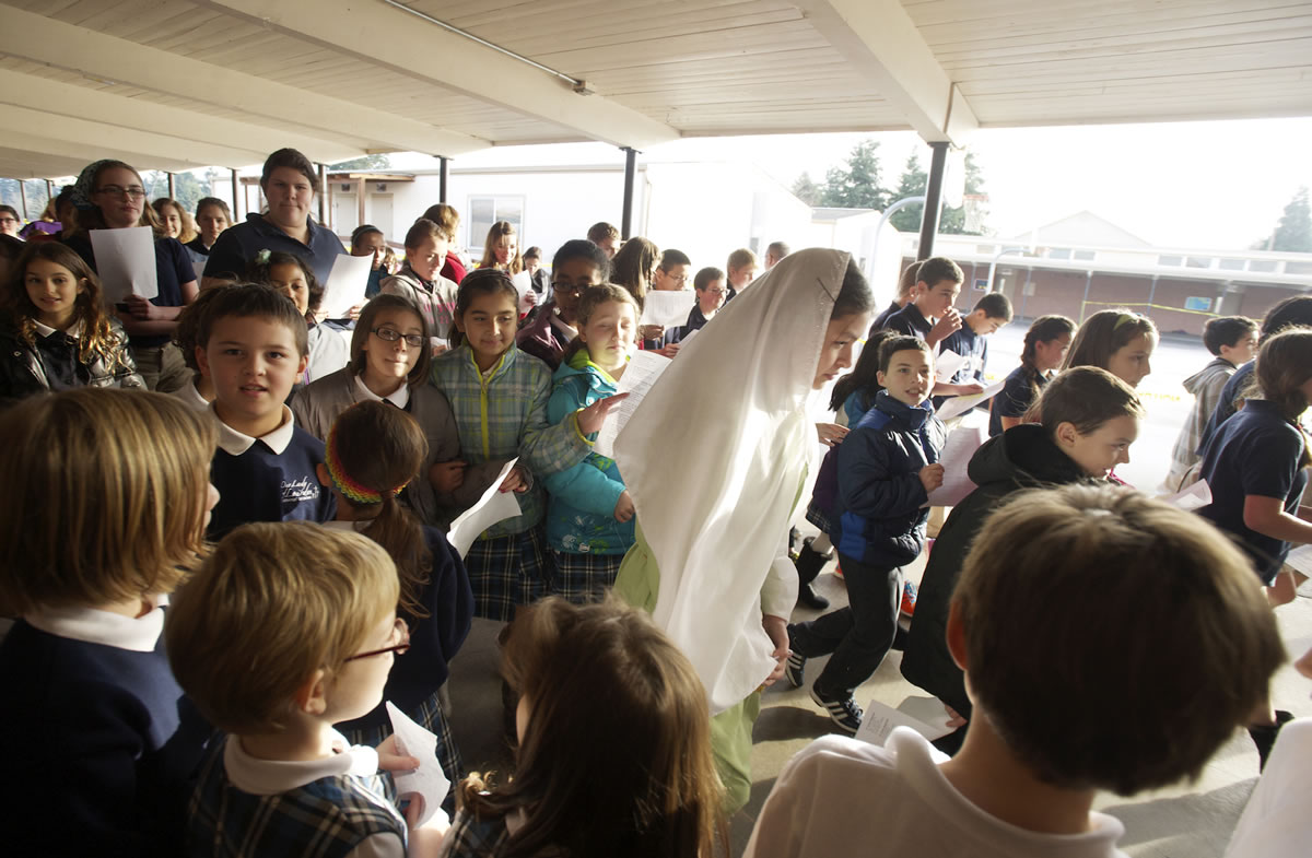 Photos by Steven Lane/The Columbian
Sixth-grader Mary Martiniello, center, playing Mary, joins other students in the Las Posadas procession Thursday at Our Lady of Lourdes Catholic School. The private school offers Spanish in a program that teaches proficiency through reading and storytelling.