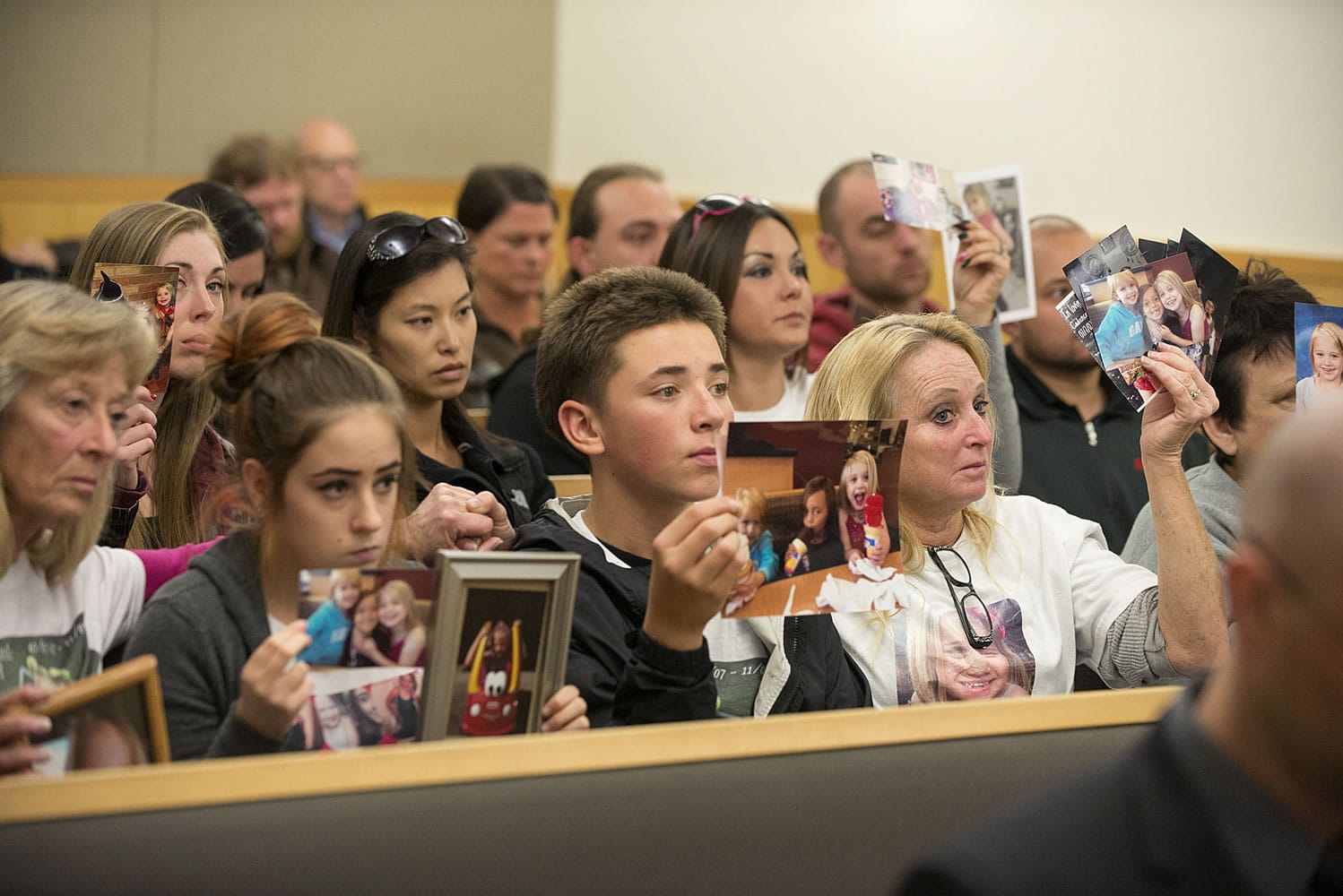Supporters of Cadence Boyer hold photos of her as Duane C. Abbott, not pictured, the driver who struck and killed Cadence as she was trick-or-treating Halloween night 2014, enters guilty pleas Wednesday in Clark County Superior Court.
