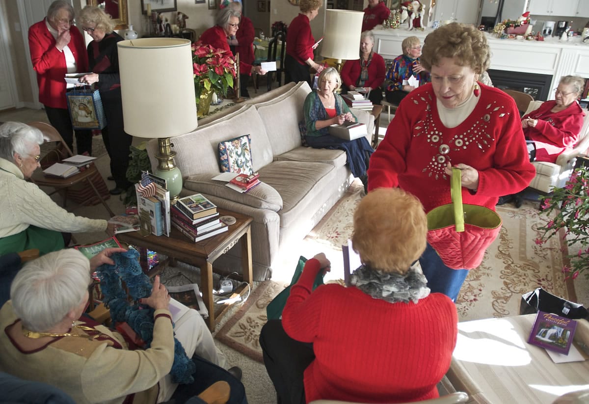 MaryAnn Cantrell, right, hands Virginia Christenson a card during the Evergreen Pollyannas Christmas party. The women met through a Girl Scout troop that they formed in 1948.