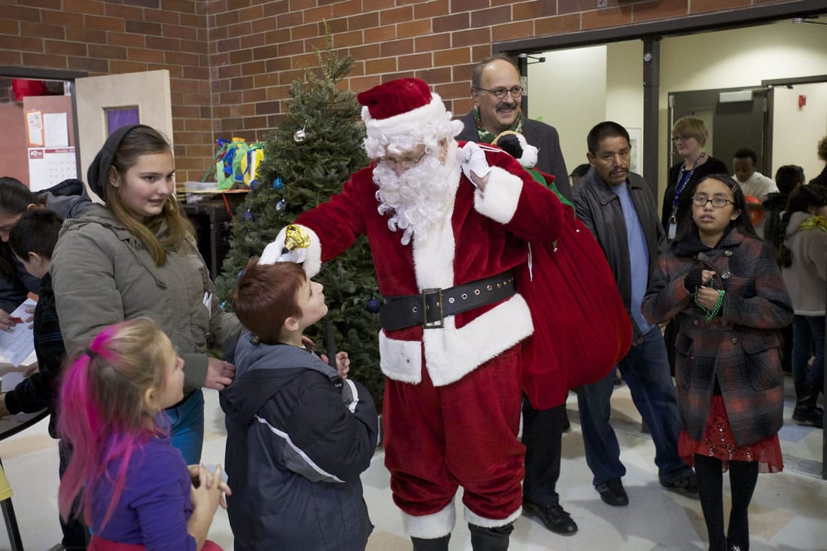 Santa greets children Thursday night at the annual Northeast Hazel Dell Holiday Party.