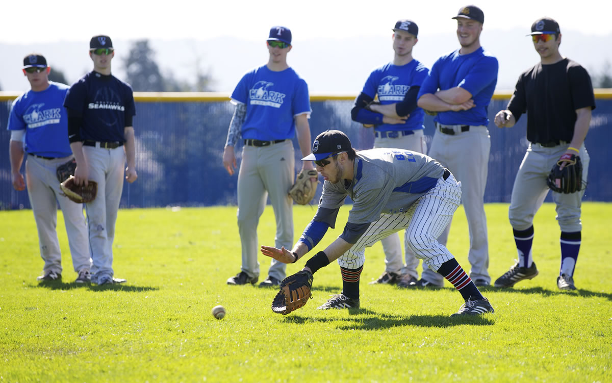 Clark College baseball player Spencer Ramsay fields a grounder in the outfield during practice, Wednesday, March 12, 2014.
