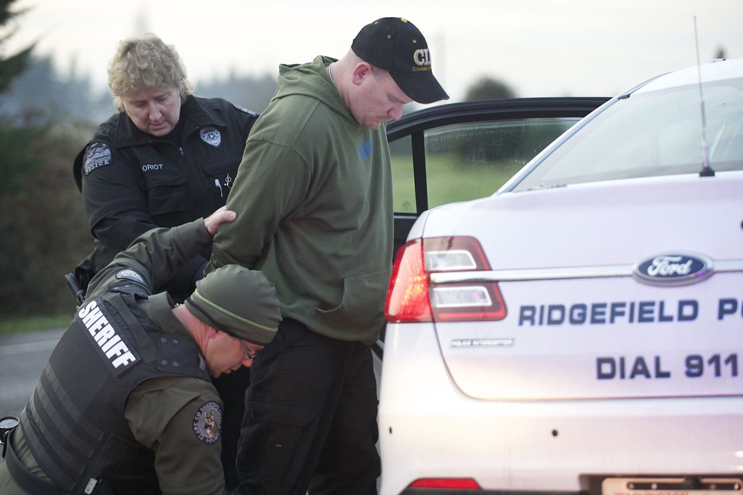 A Ridgefield police officer and a sheriff deputy arrest a man during an investigation of a home invasion robbery on Thursday afternoon.